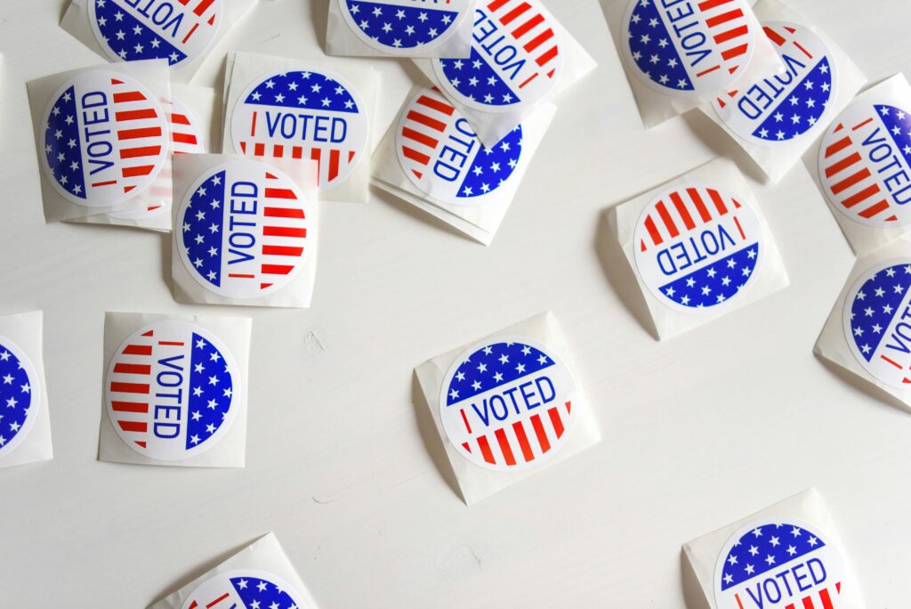 Red white and blue stickers saying I Voted on a white background